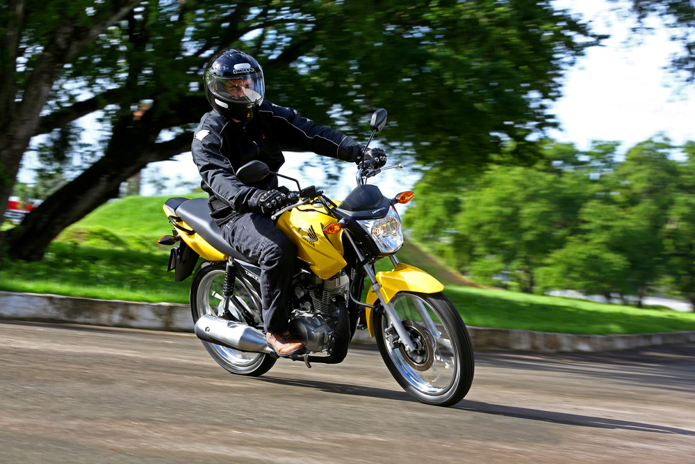 Motoqueiro conduzindo motocicleta amarela