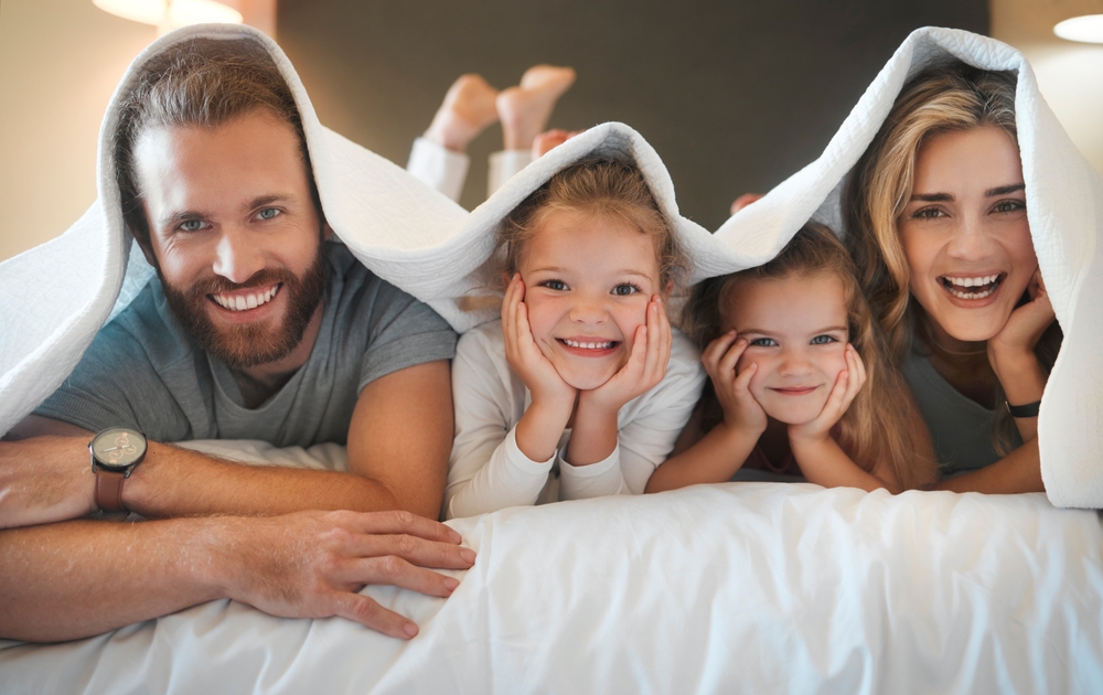 família na cama e sorrindo