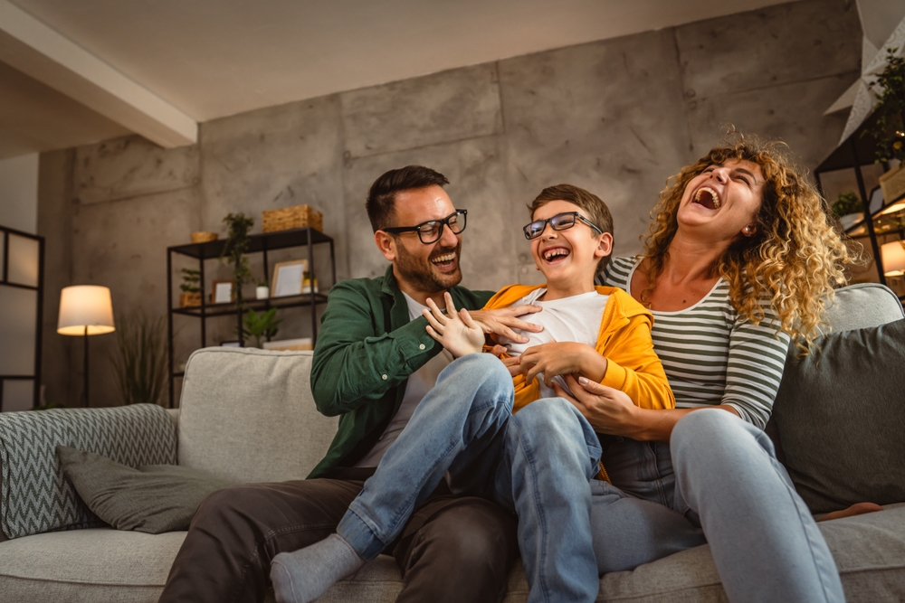 Família feliz brincando e sorrindo no sofá