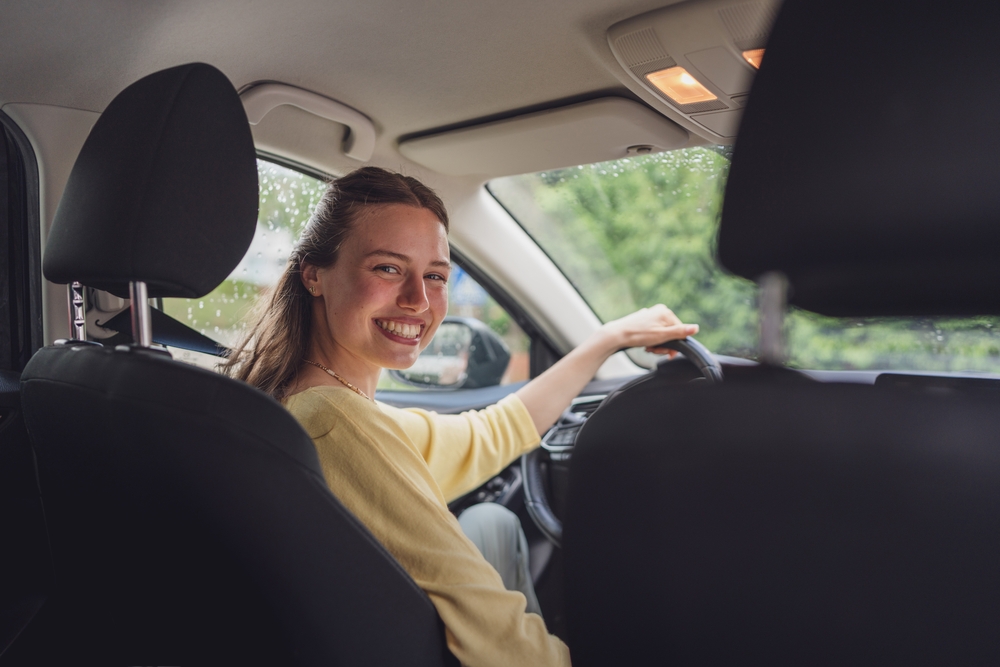 Mulher sorridente ao volante