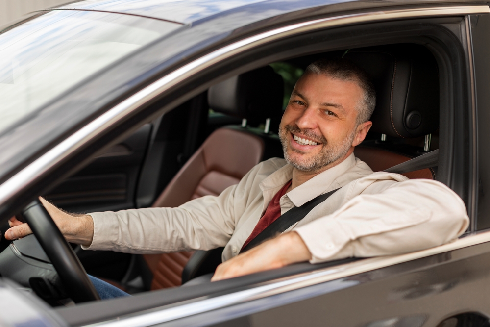 Homem sorrindo ao volante