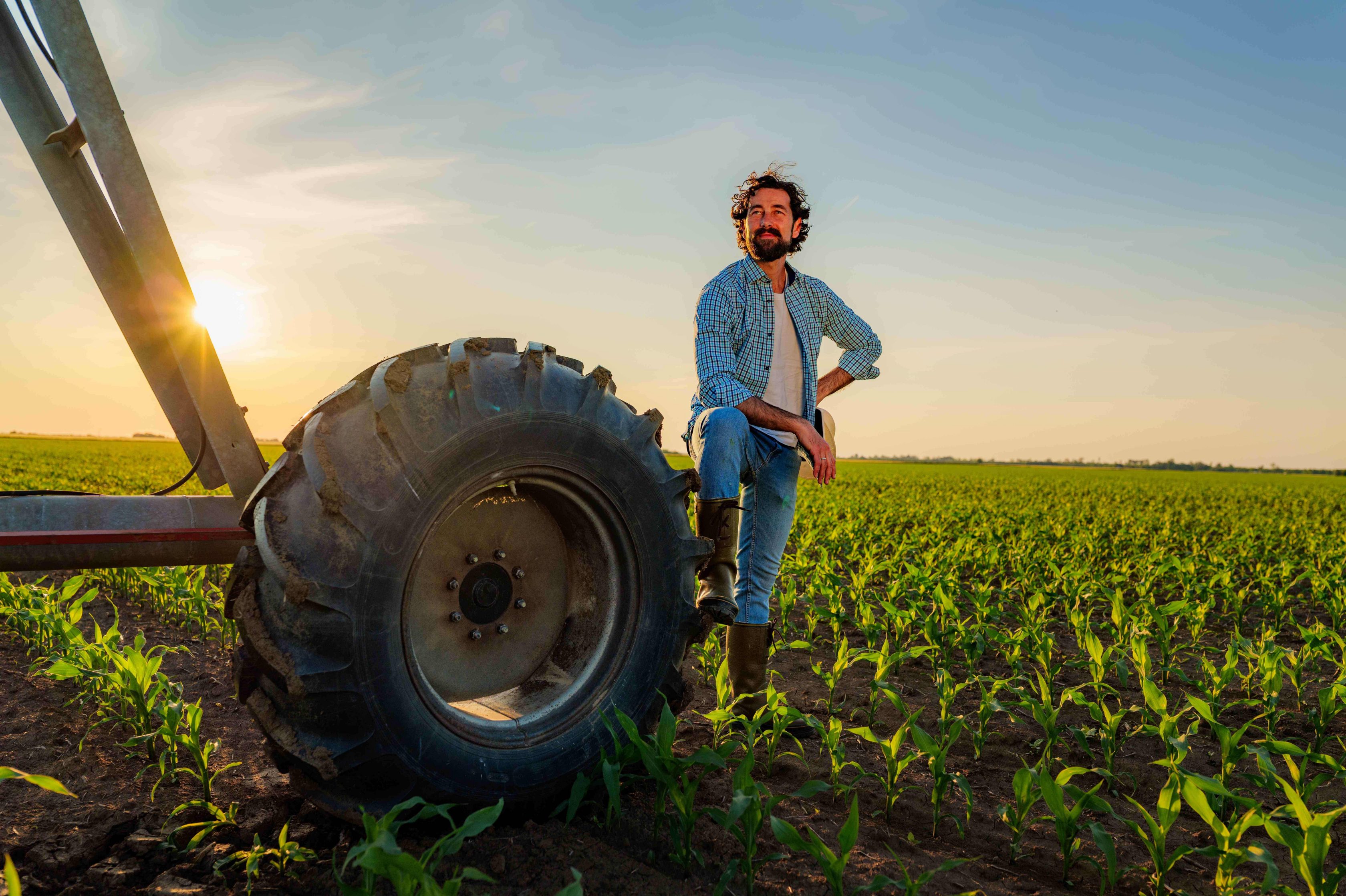 Fazendeiro próximo de pneu de máquina agrícola
