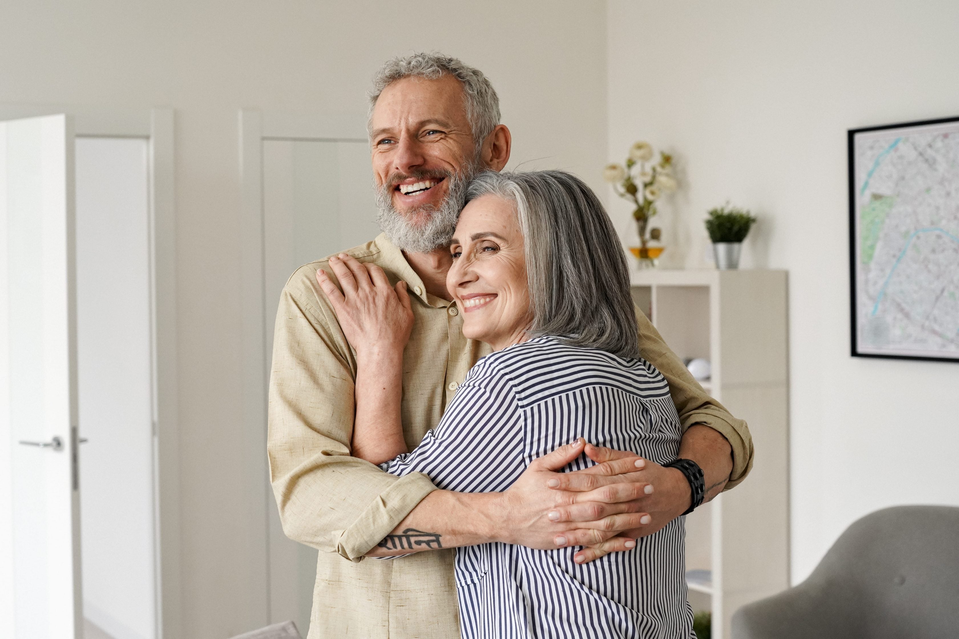 Casal sênior, homem e mulher, abraçados e sorrindo com ternura