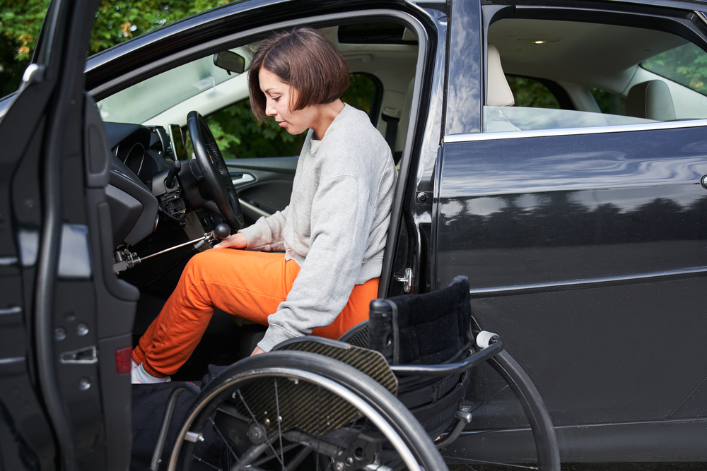 Mulher com deficiência saindo de seu carro adaptado