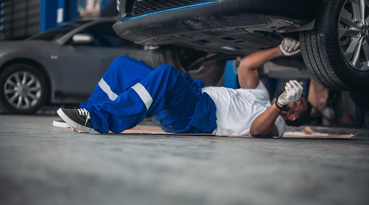 Mecânico analisando a suspensão do carro