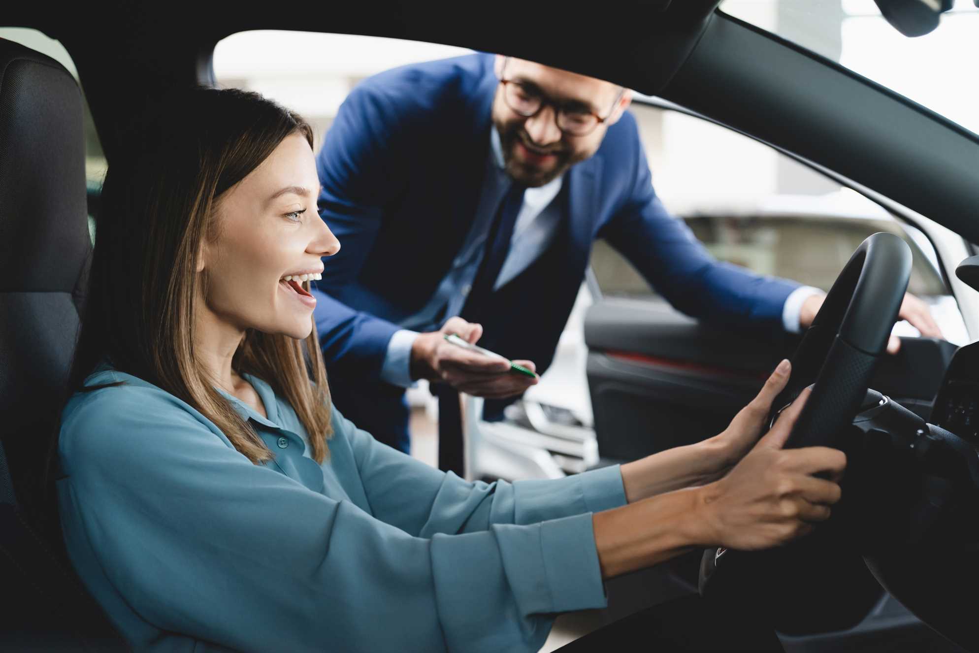 Vendedor de carro apresentando veículo para uma cliente