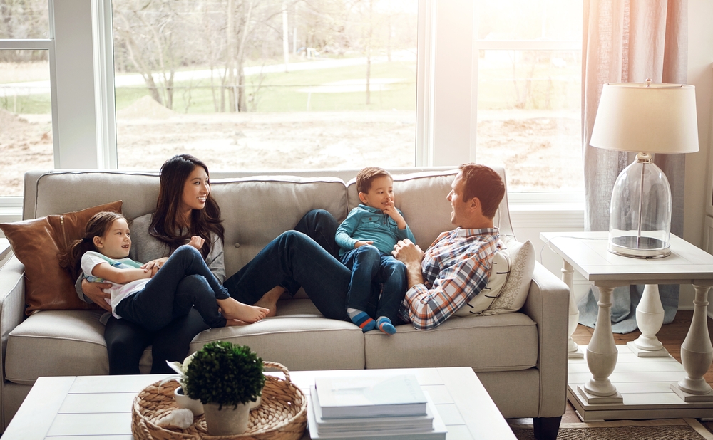 Família feliz, pai mãe e fi lhos, deitados no sofá