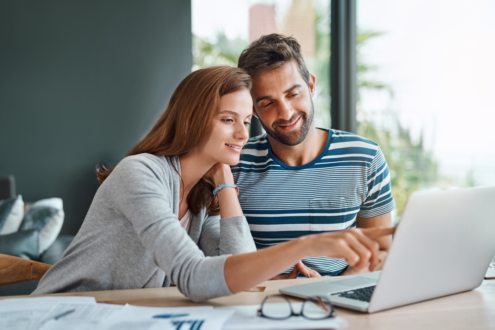 Casal jovem usando computador e fazendo planejamento financeiro
