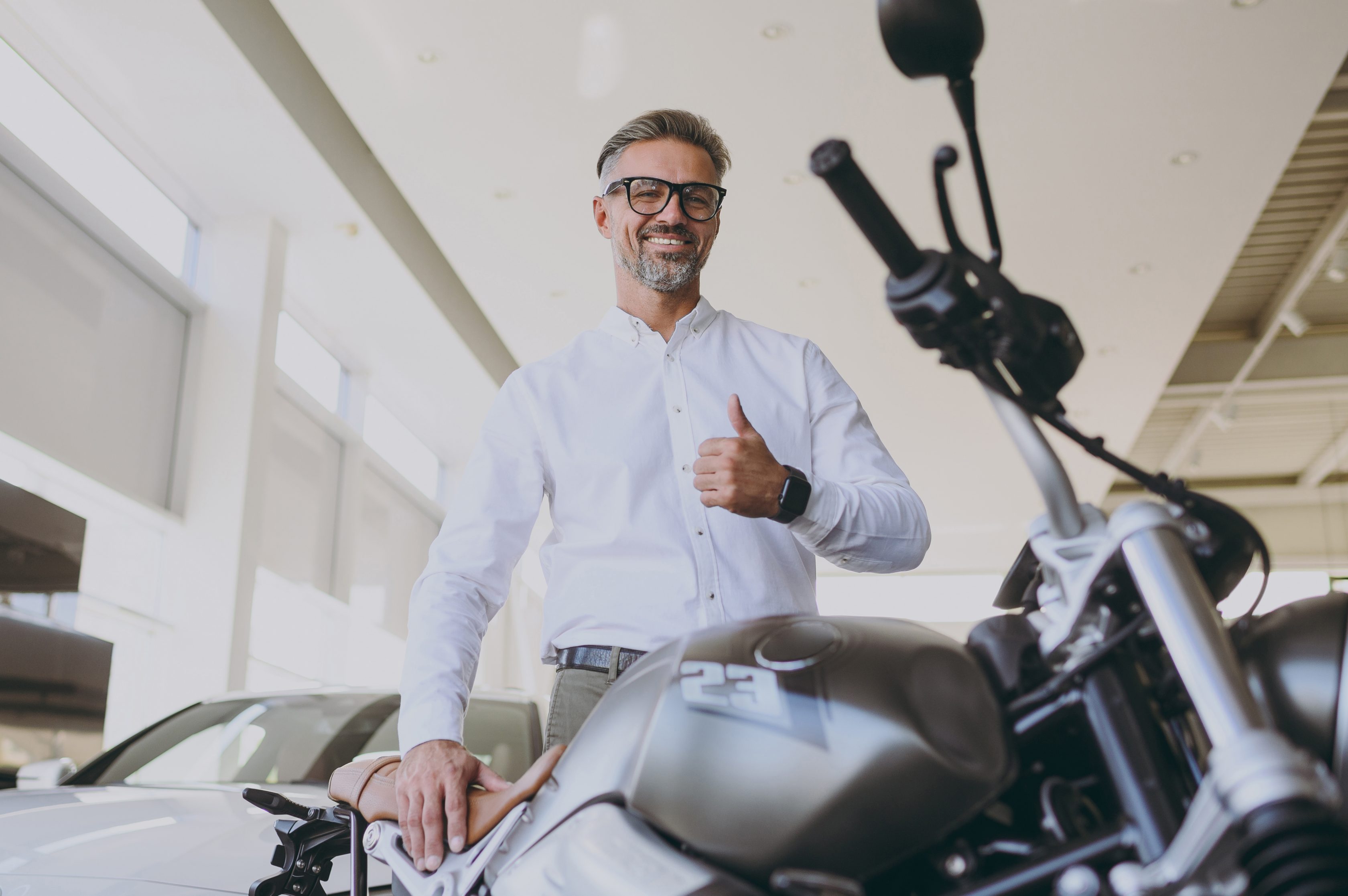 Homem sorrindo em frente à sua moto