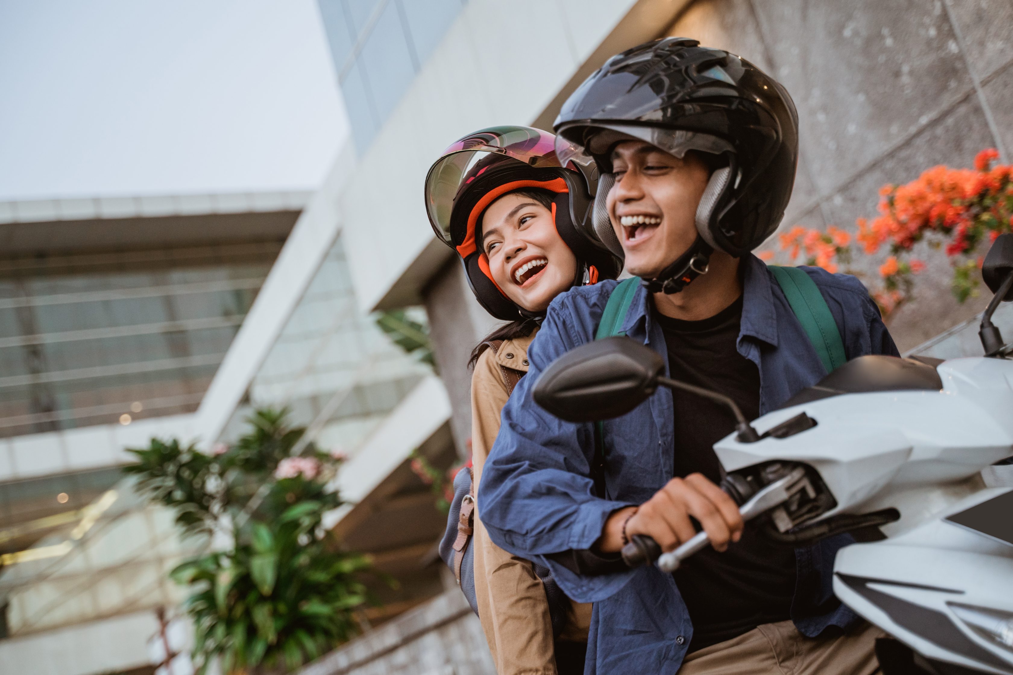 Homem e mulher em cima de uma moto e sorrindo