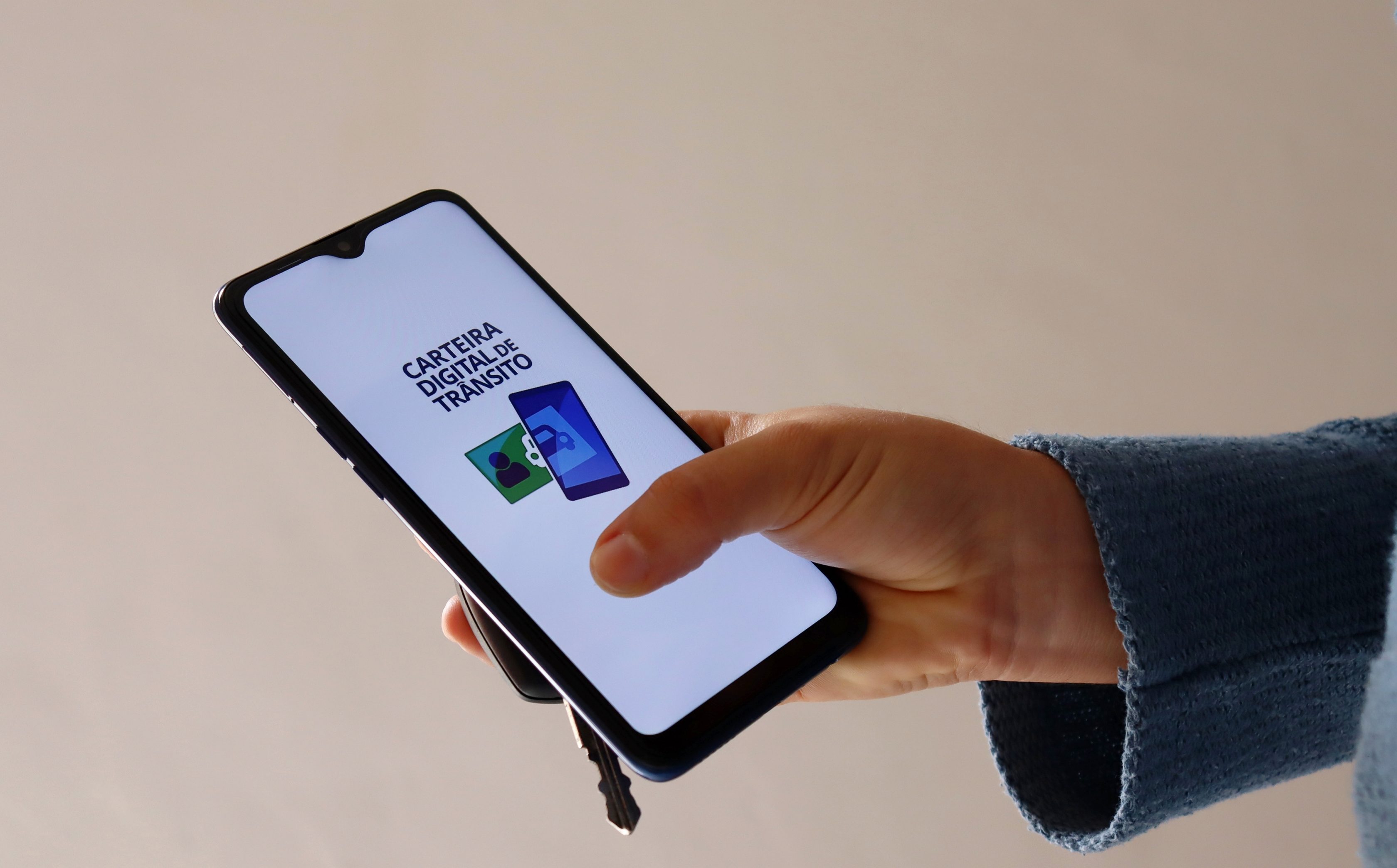 Homem com celular na mão com o aplicativo da CNH digital