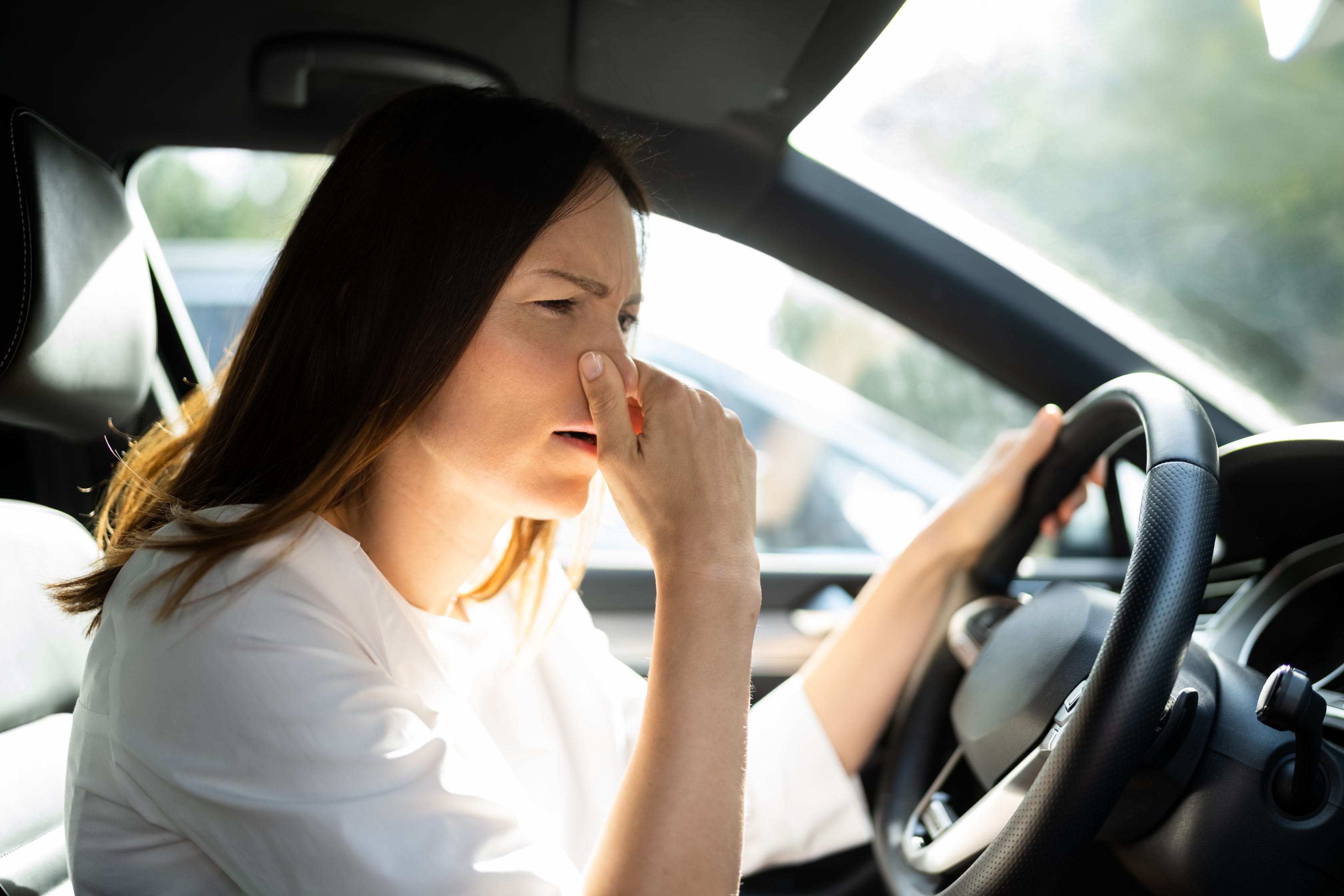 Mulher sentindo cheiro de gasolina no carro
