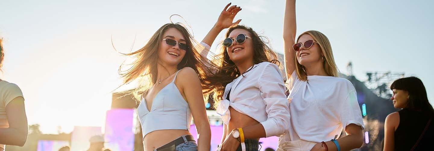 Três amigas se divertindo em um festival de música de tarde