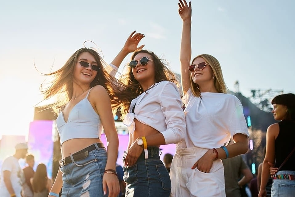 Três amigas se divertindo em um festival de música de tarde
