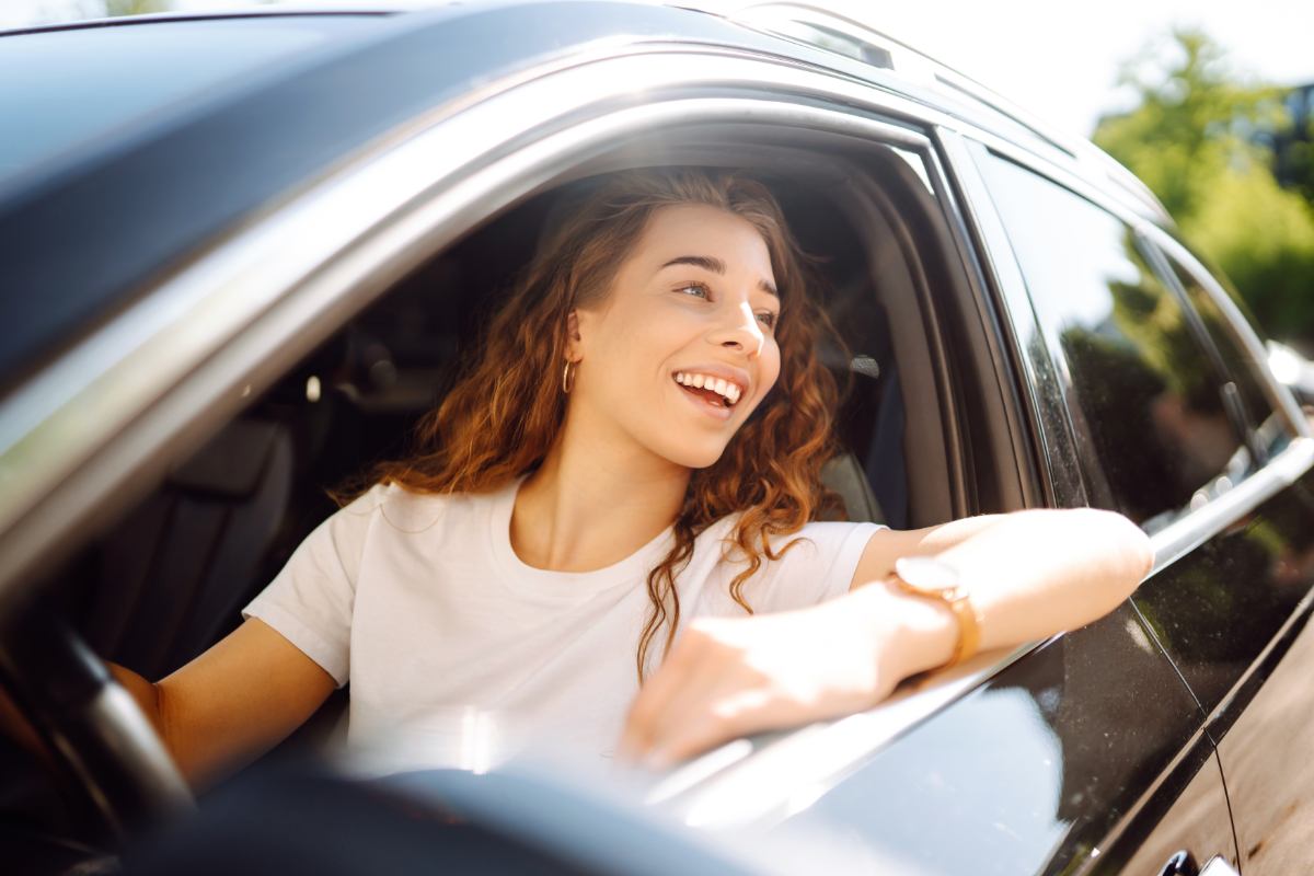 Motorista sorrindo enquanto dirige seu carro