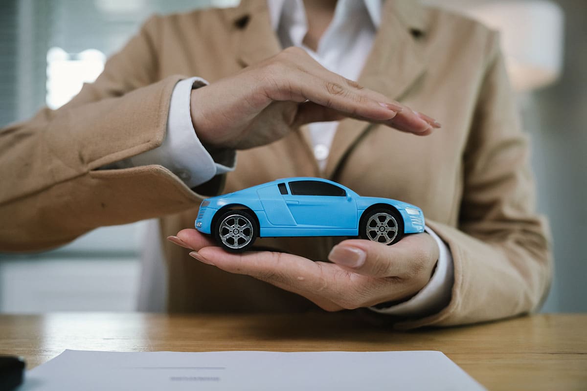 Pessoa segurando miniatura de carro azul