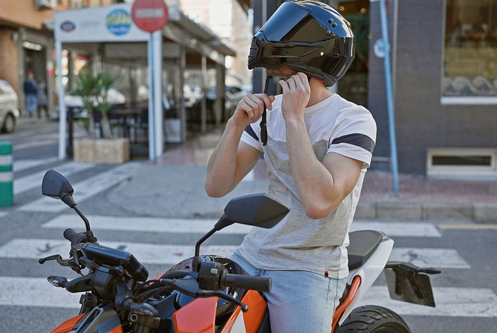 Homem colocando capacete em cima de sua moto
