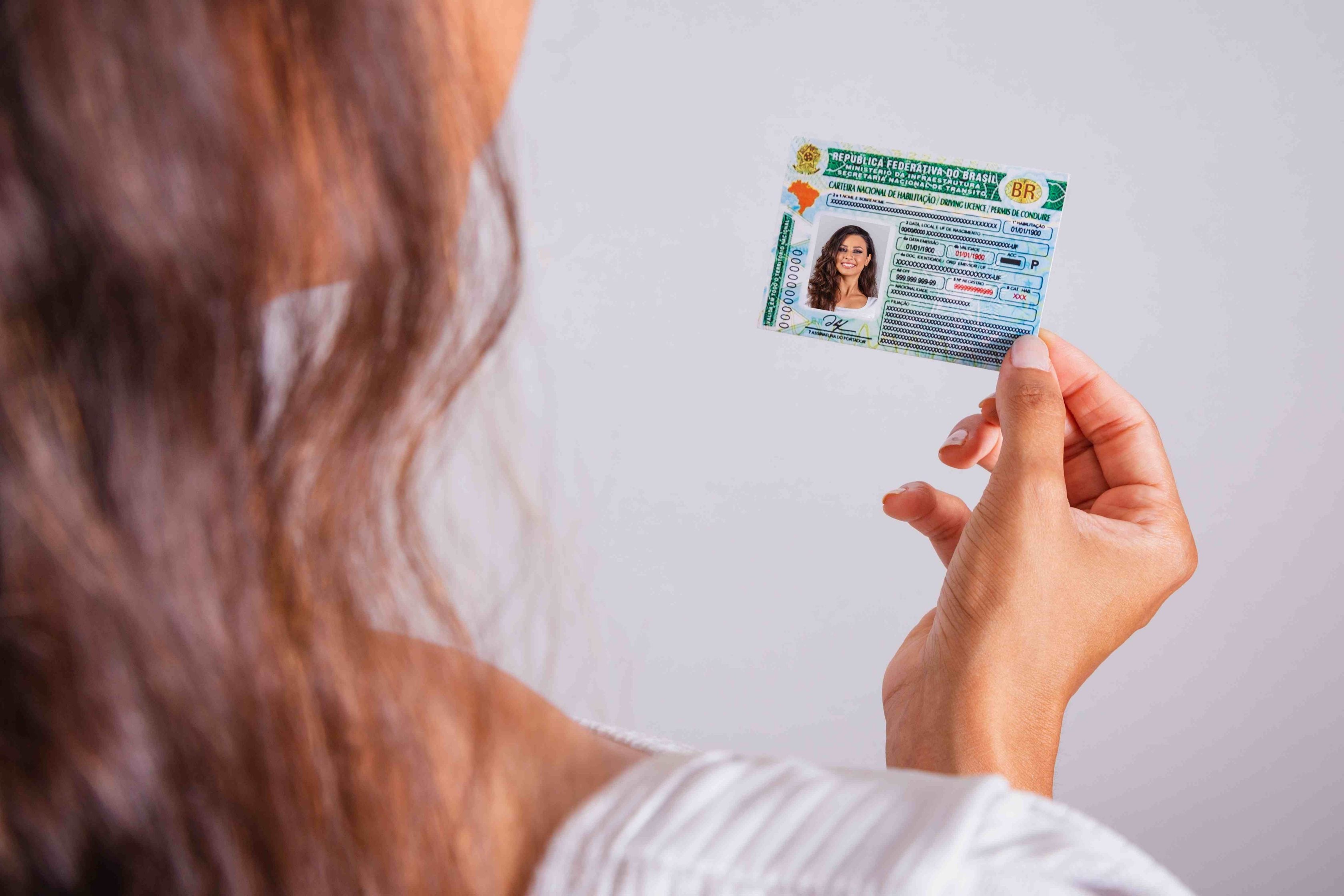 Mulher segurando sua carteira de motorista