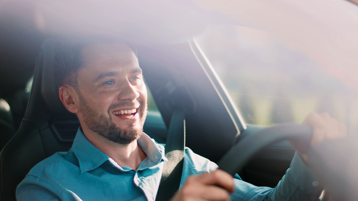 Homem feliz dirigindo seu carro