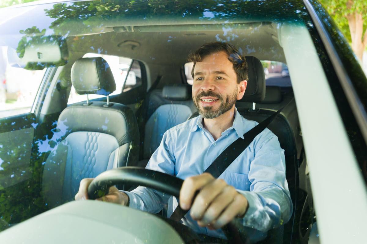 Homem adulto feliz dirigindo carro