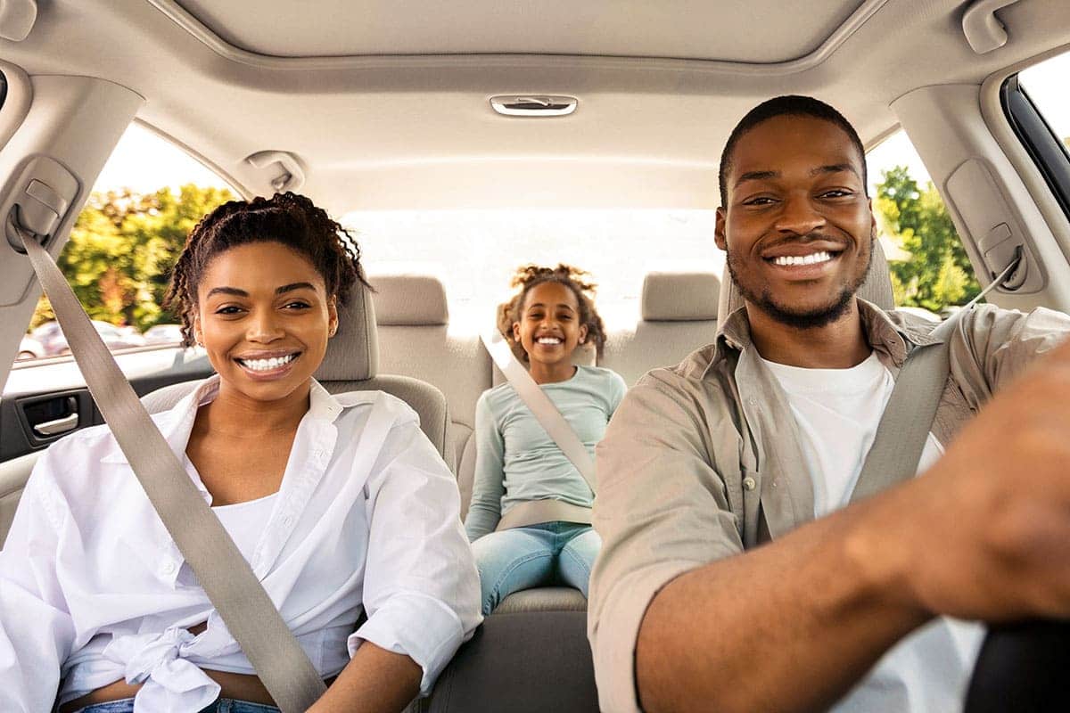 Família sorrindo enquanto viaja de carro