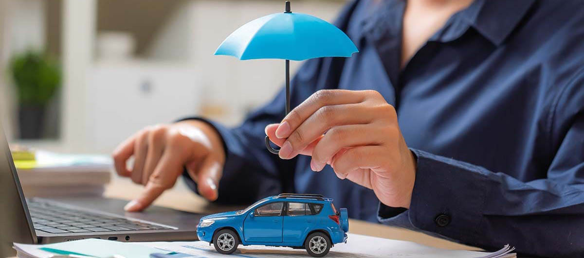 Mulher segurando um guarda-chuva em cima e uma miniatura de carro, representando o seguro auto