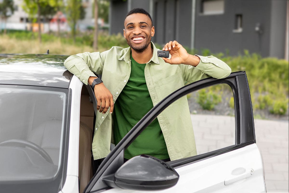 Homem segurando as chaves de seu novo carro