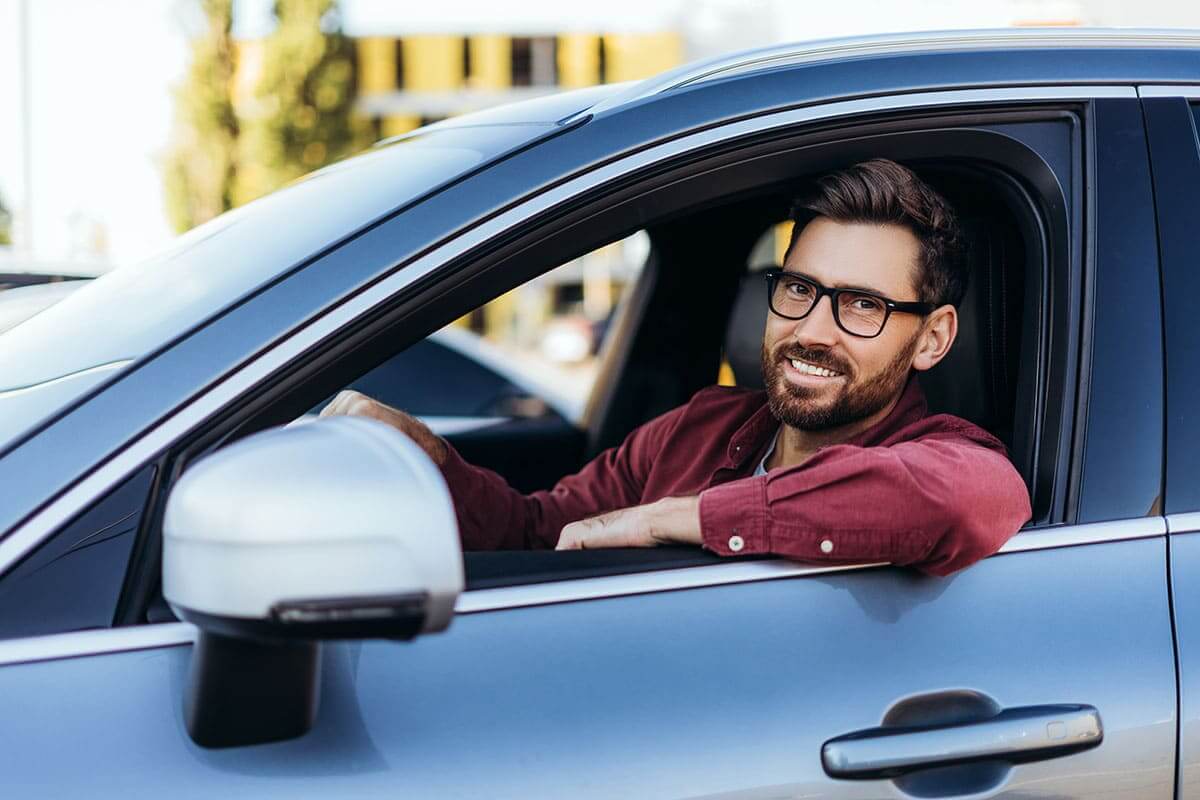 Homem sorrindo ao volante 