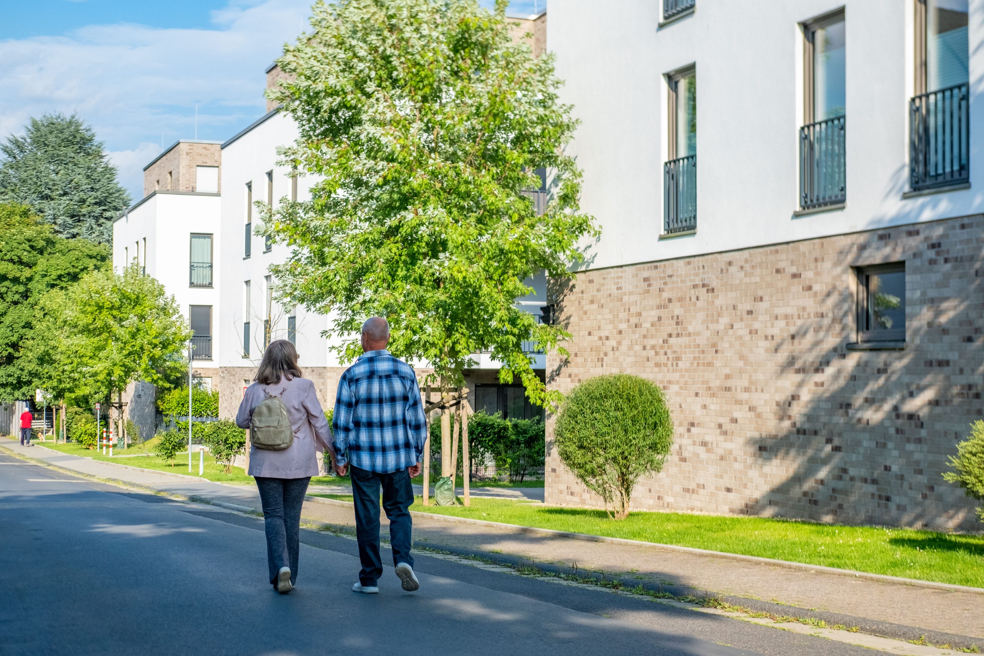 Casal andando de mãos dadas em rua do condomínio