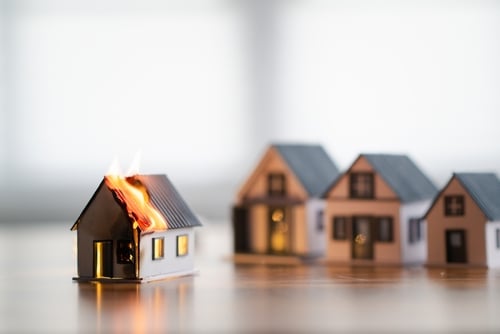 miniatura de casa pegando fogo representando seguro de casa