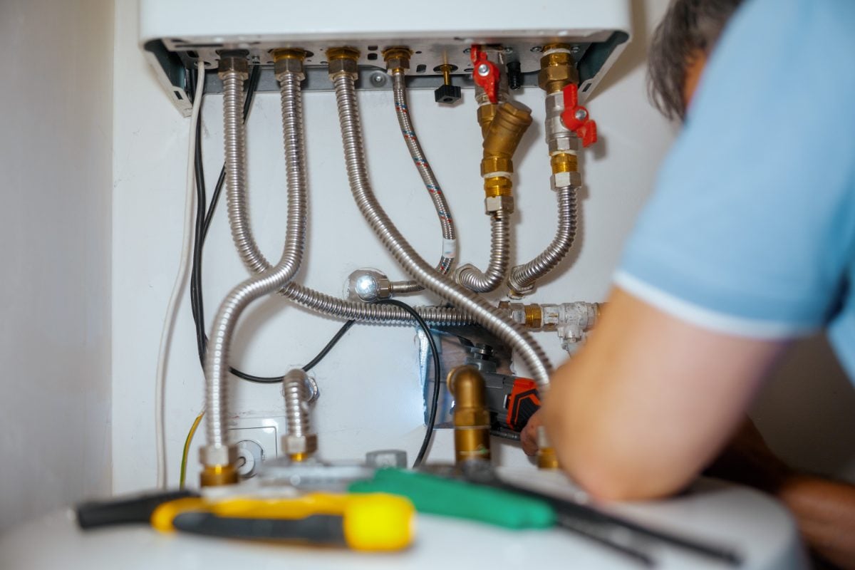 Profissional realizando manutenção preventiva em um aquecedor residencial
