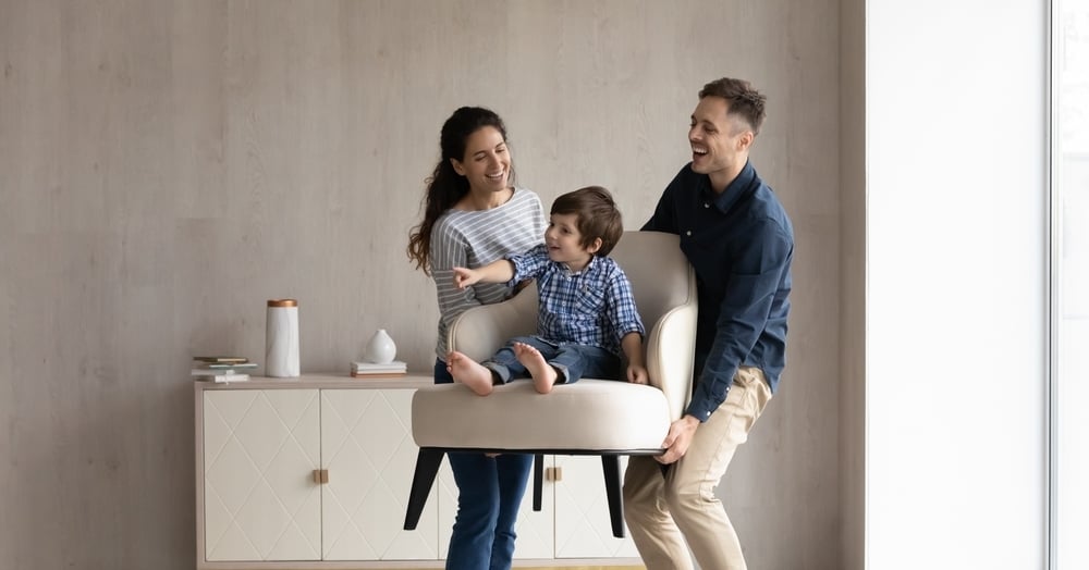 Família feliz segurando filho pequeno sentado em uma cadeira