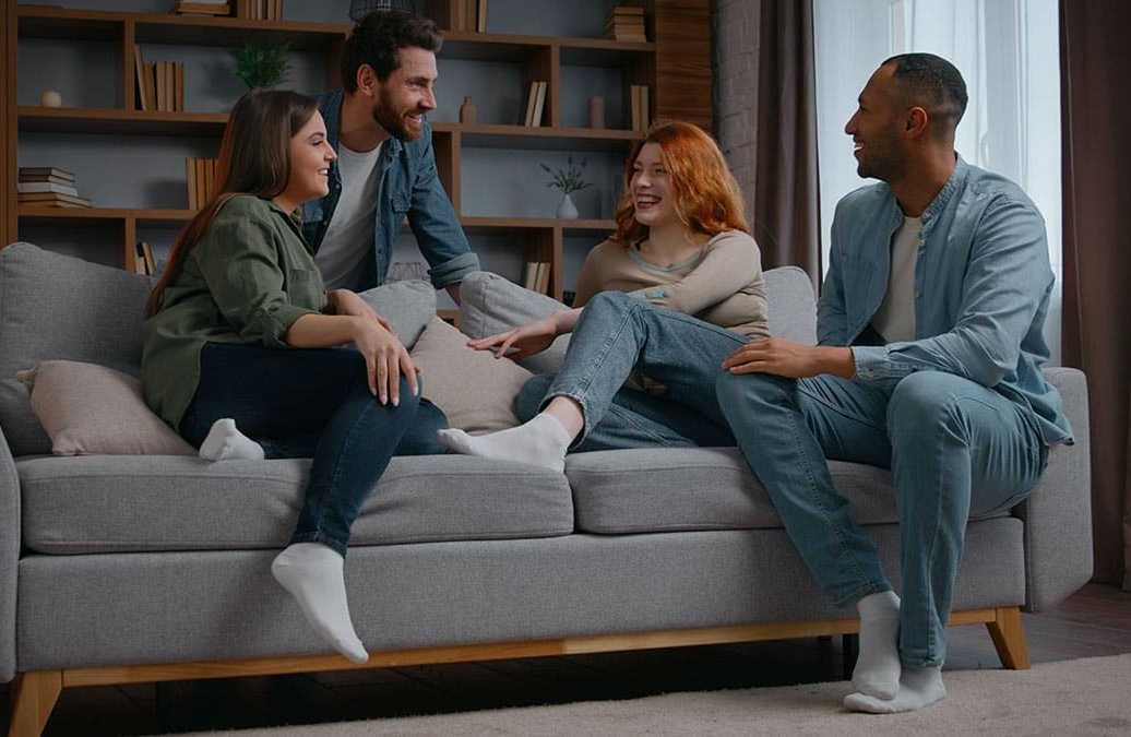 Quatro amigos sentados no sofá se divertindo