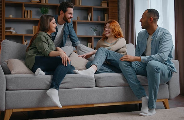 Quatro amigos sentados no sofá se divertindo