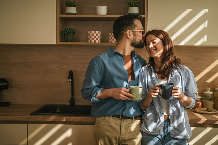 Casal tomando café e se abraçando na cozinha