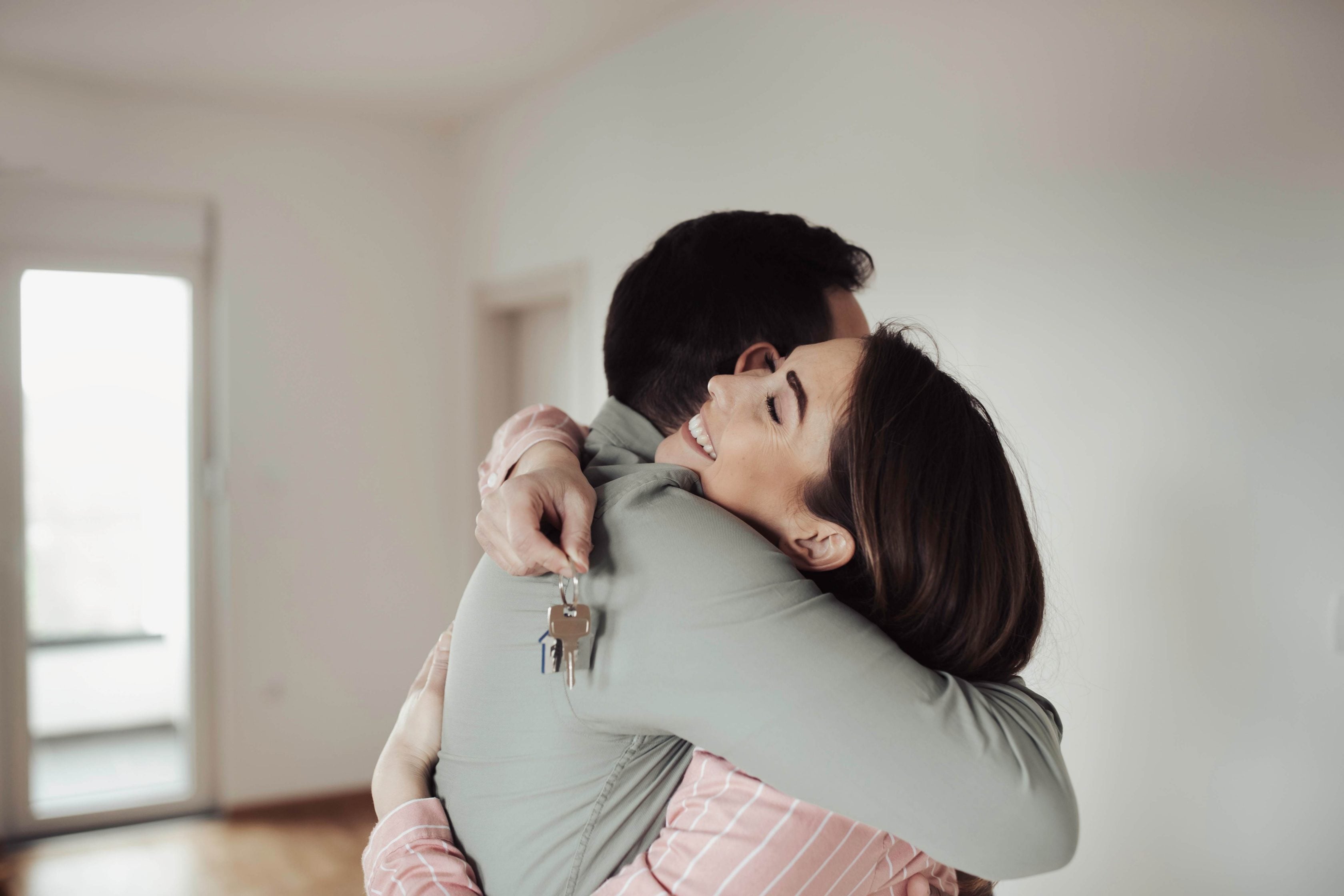 Casal abraçados em seu novo apartamento