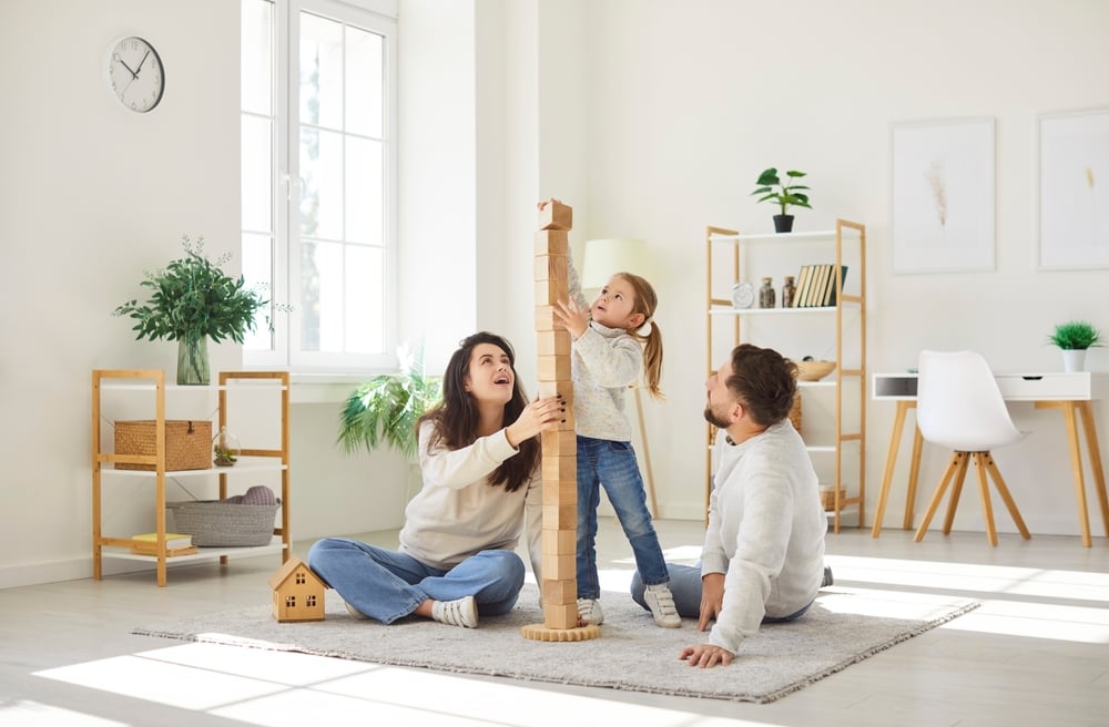 Família feliz brincando no chão do apartamento