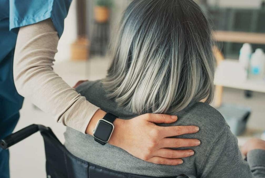 Enfermeira ajudando paciente com invalidez por doença