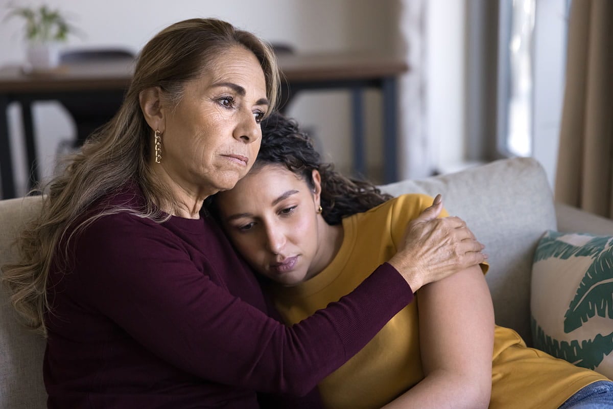 Mãe e filha se abraçando e confortando