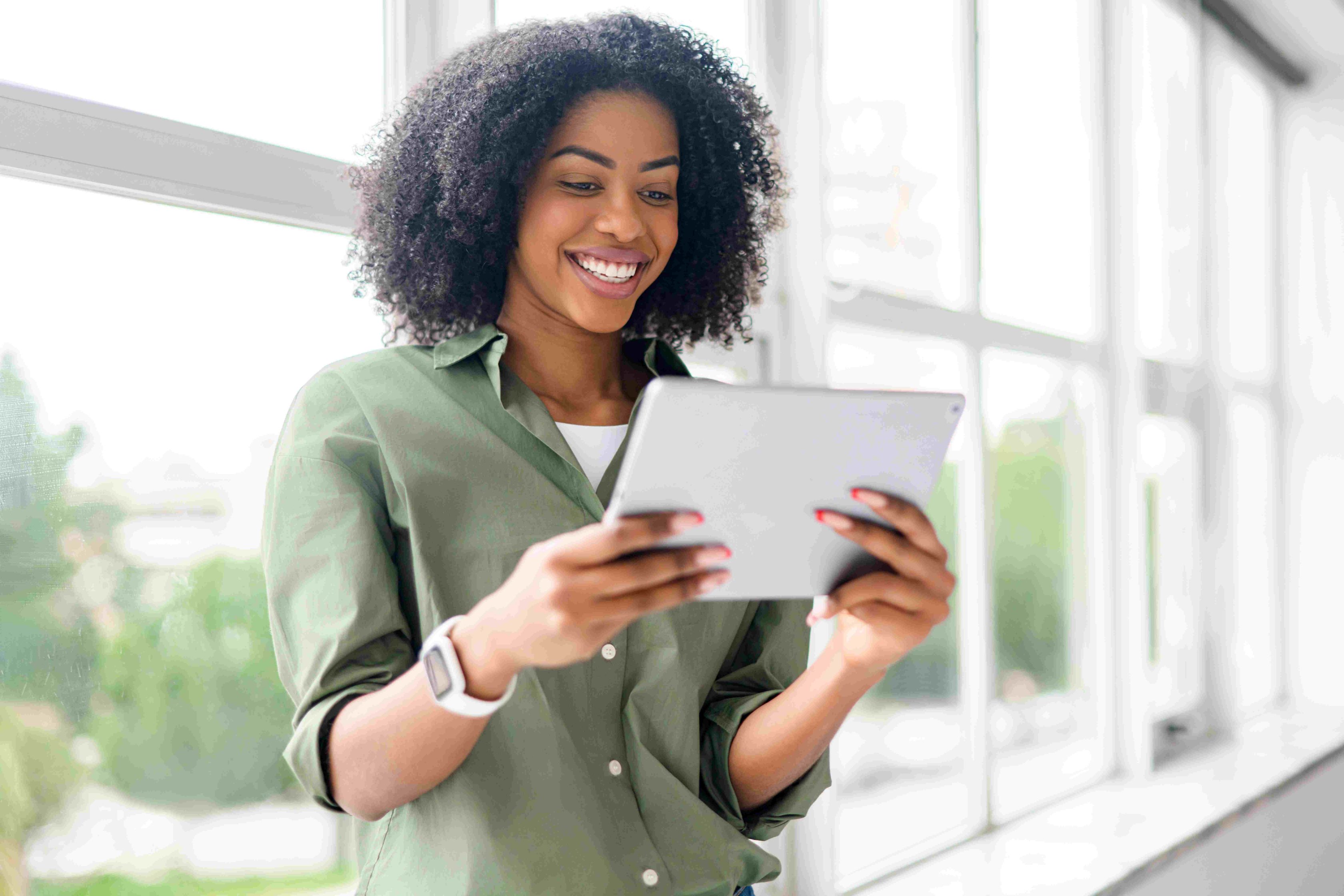 Mulher sorrindo enquanto usa tablet