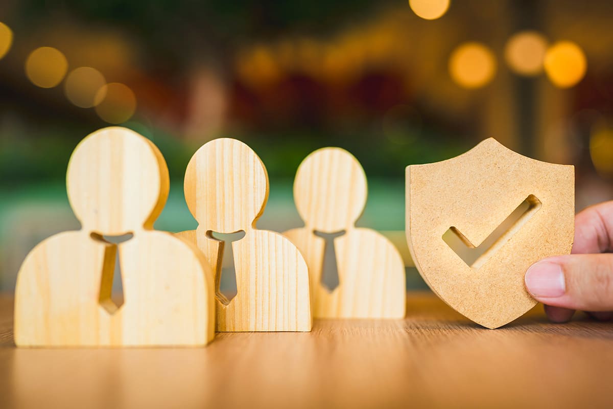 Figuras de madeira representando proteção do seguro de vida