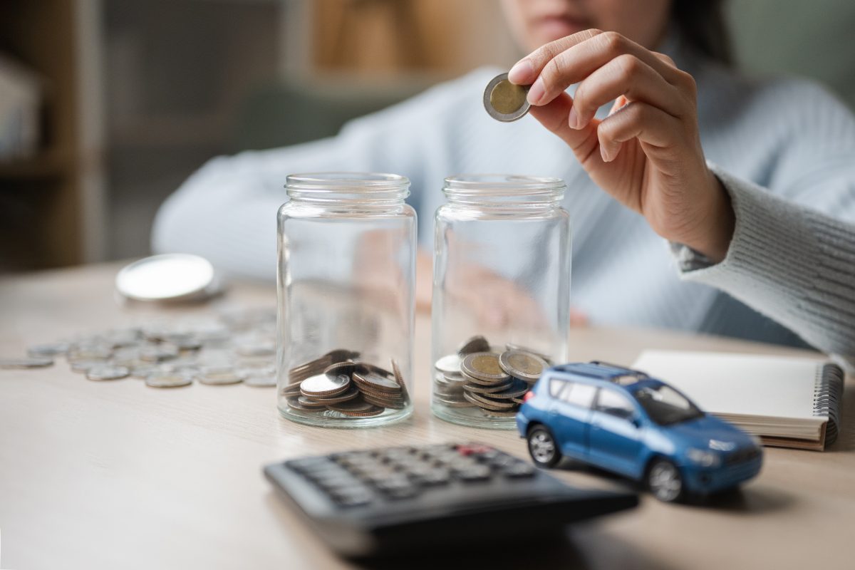 Pessoa colocando moedas em um pote simbolizando a reserva de emergência