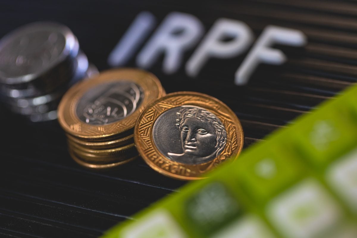 Moedas brasileiras com sigla IRPF ao fundo