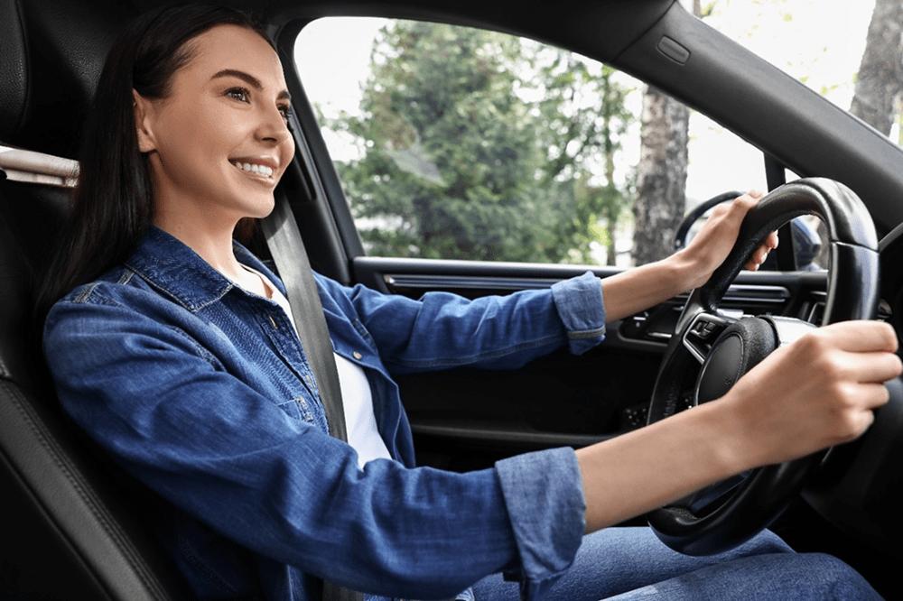 Motorista sorrindo ao dirigir o carro