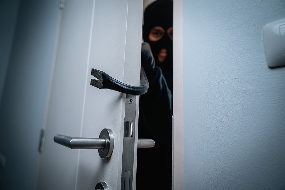 Homem invadindo casa com pé de cabra