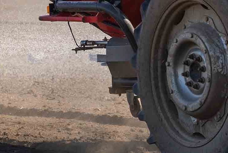 Trator espalhando fertilizante no solo