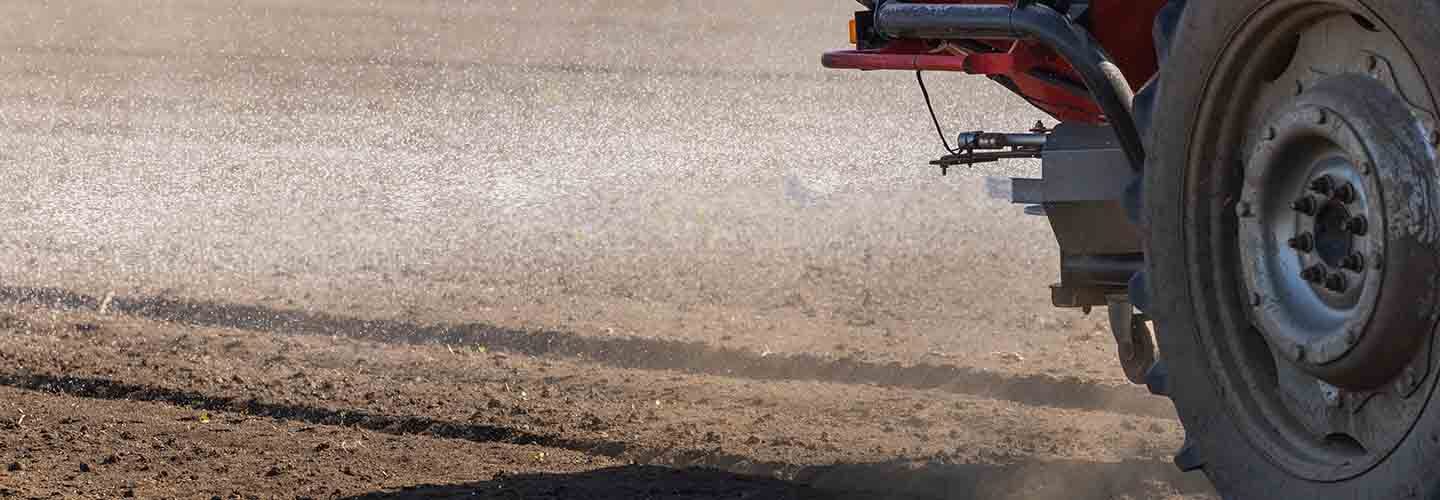 Trator espalhando fertilizante no solo