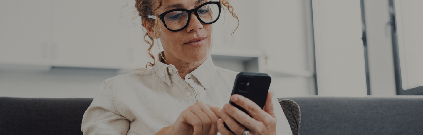Mulher no escritório com celular na mão