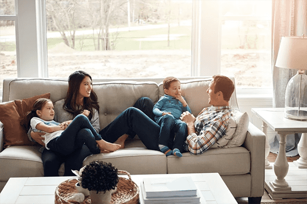 Família feliz, pai mãe e fi lhos, deitados no sofá