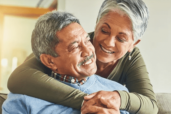 Casal de idosos abraçados e sorrindo
